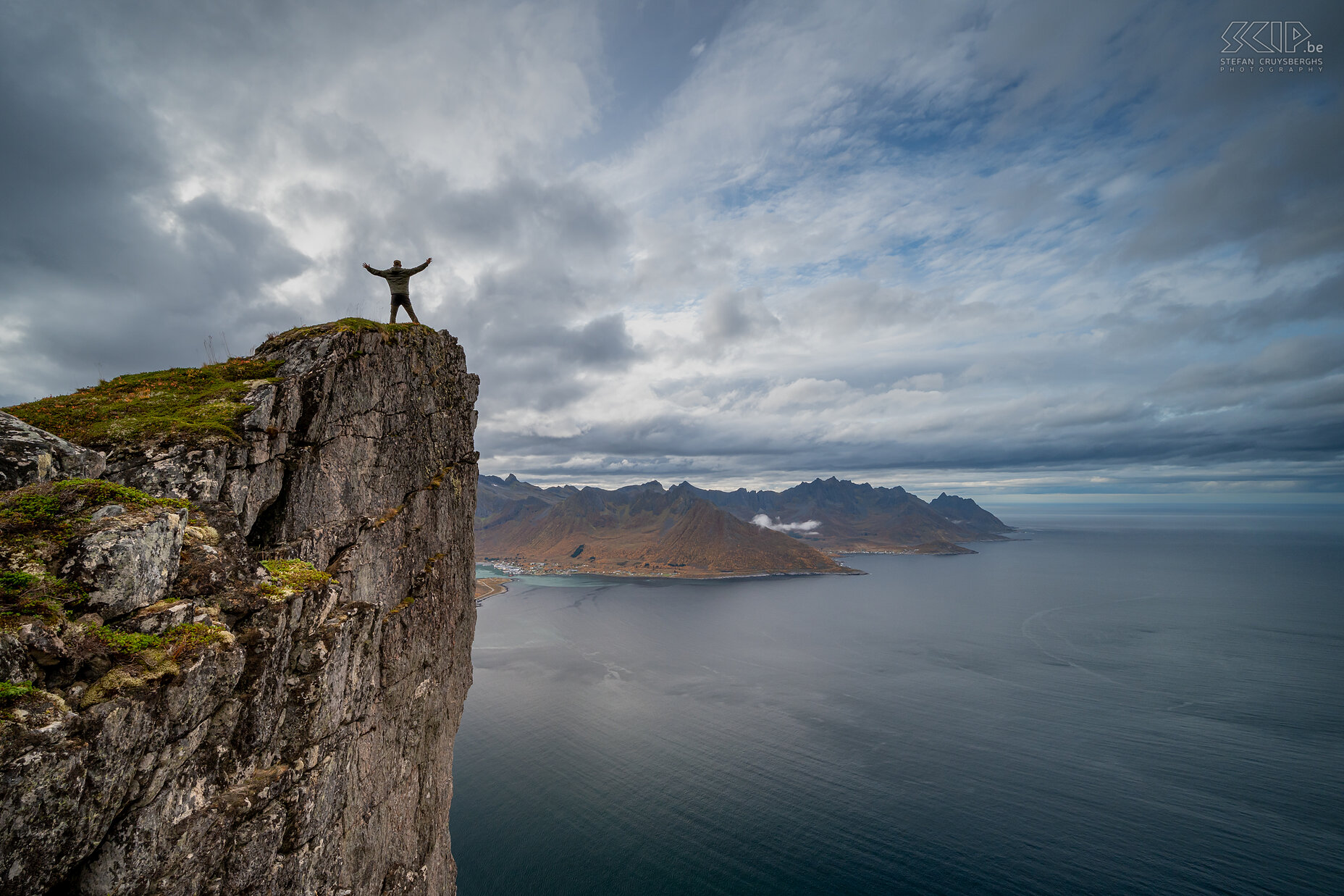 Senja - Hesten - Mefjorden - Stefan Selfie on a rock wall of the Hesten with a view of the Mefjorden and the village of Senjahopen on the other side Stefan Cruysberghs